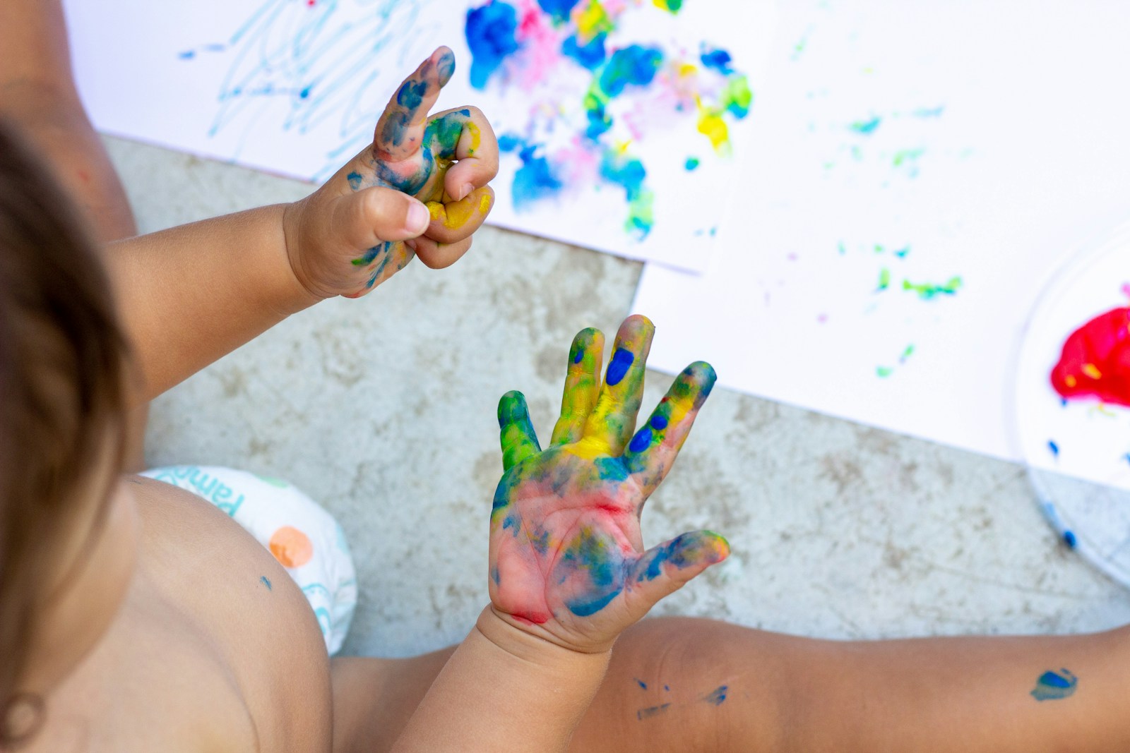 Bunte Farbe an Kinderhänden